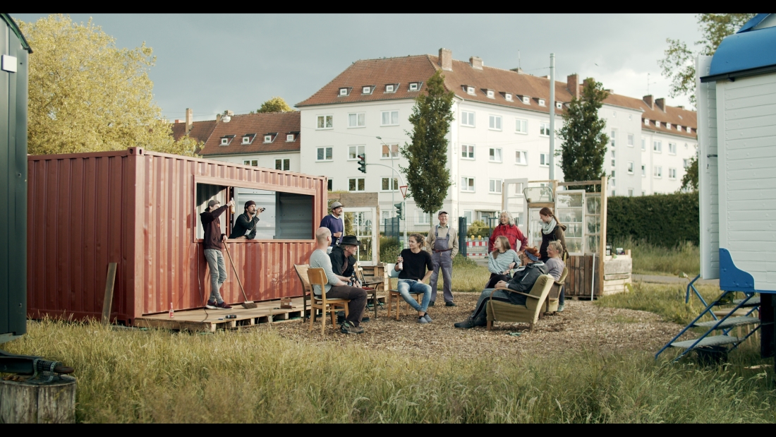 Leute sitzen vor einem Container, der ein Fenster hat