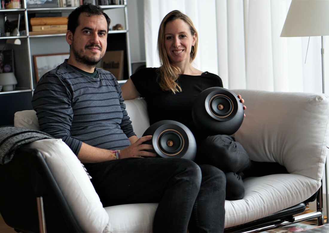 Pablo Ocqueteau und Philine von Düszeln sitzen auf der Couch und zeigen die Mapu Speakers. 