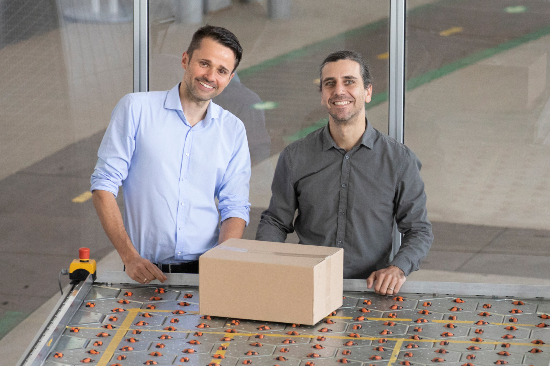 Hendrik Thamer (links) und Gründer Claudio Uriarte (rechts) am Fördersystem celluveyor.