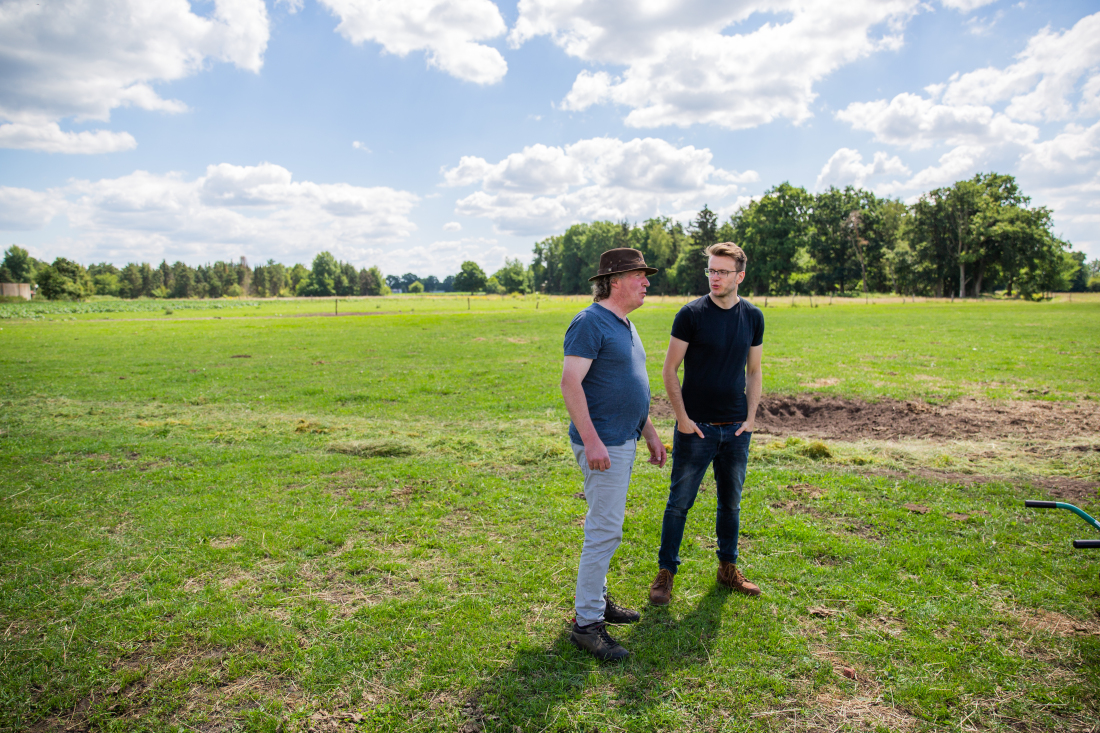 Moritz Armbrust bespricht sich mit einem Landwirt auf dem Feld